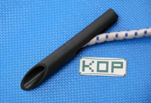 Close-up of a black, conical plastic nozzle with a cylindrical shape on a blue textured surface, next to a piece of white and blue braided rope and a label with the text 'KOP', which are part of the 8″ Scaffold Bungees and 12″ Scaffold Bungees set.